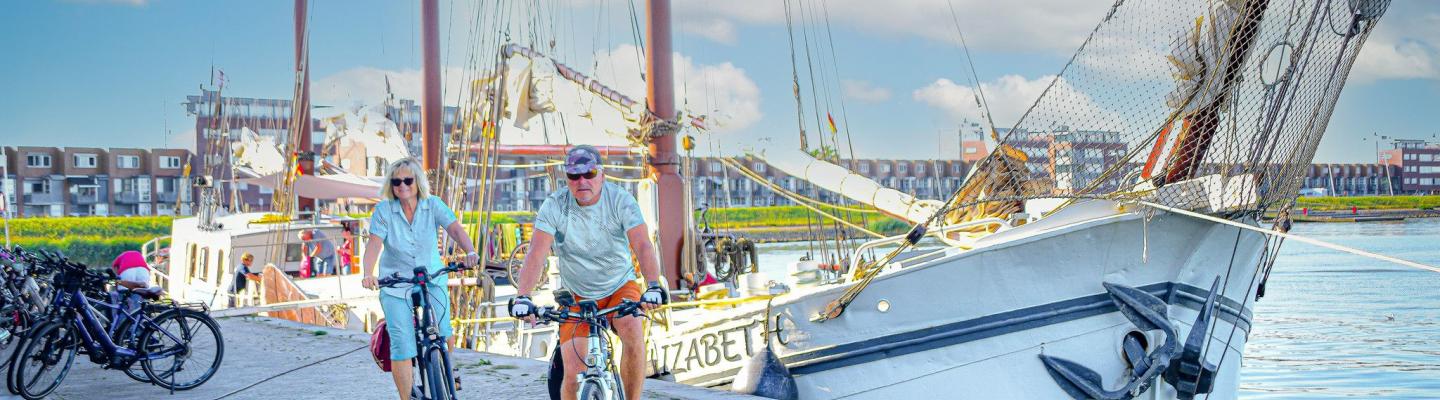 Radfahrer vor dem Segelboot Elizabeth am Hafen